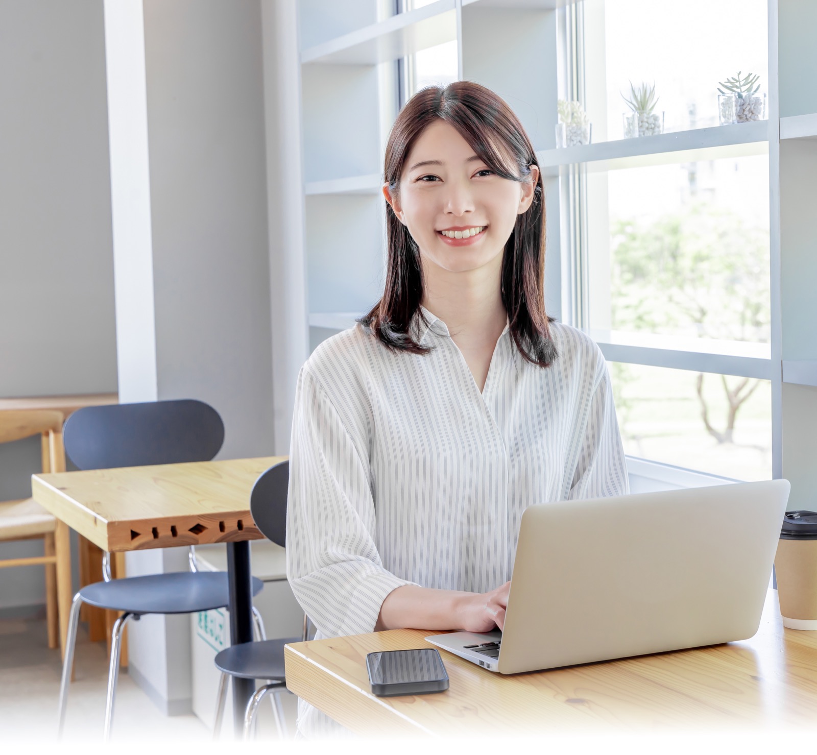 カフェでノートパソコンを使って学ぶ女性
